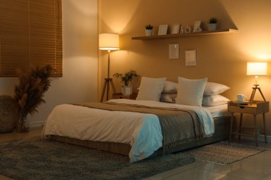 Geceleri karanlık odanın içinde yataklar, masalar ve parlayan lambalar.