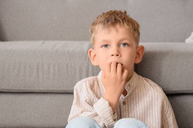 Evdeki kanepede çivi yiyen küçük çocuk, yakın plan.