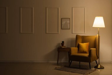 Akşamları koltuğu, masası ve parlayan lambası olan karanlık odanın içinde.