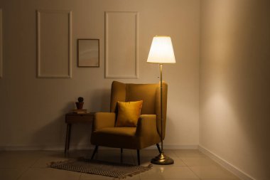 Akşamları koltuğu, masası ve parlayan lambası olan karanlık odanın içinde.