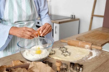 Genç bayan mutfakta kurabiye için hamur hazırlıyor.