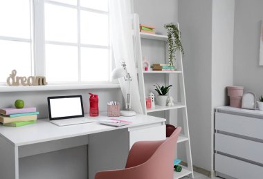 Çalışma yeri, raf ünitesi ve penceresi olan çocuk odasının içi