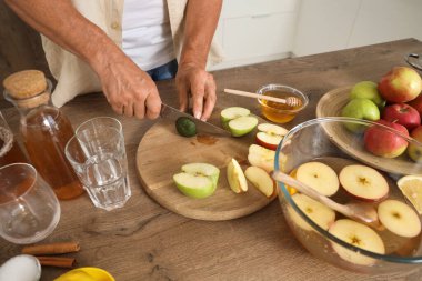Mutfakta elma suyu için kireç kesen olgun bir adam, yakın plan.