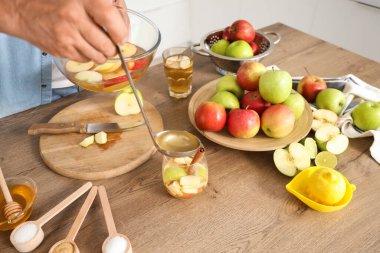 Olgun bir adam mutfaktaki cama elma şarabı döküyor.