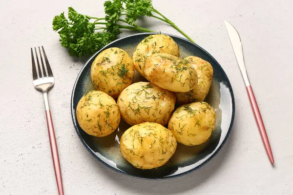 Beyaz arka planda dereotlu ve maydanozlu haşlanmış bebek patatesler.