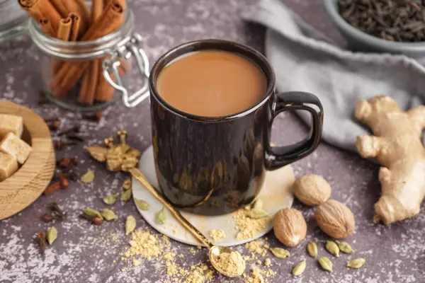 Bir fincan lezzetli masala çayı ve farklı baharatlar. Arka planda, yakın plan.