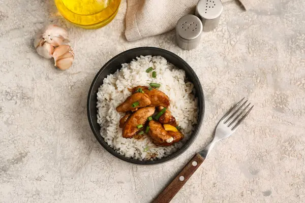 Lezzetli tatlı ve ekşi tavuk, siyah kasede pilav ve gri grunge arka plan.