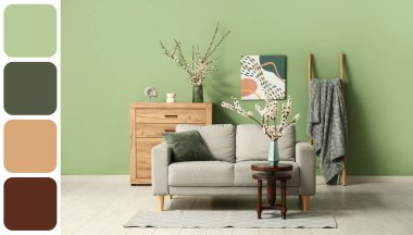 Odanın içinde kanepe ve çiçek açan dallar var.