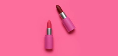 Pembe arka planda farklı ruj izleri, üst görünümde.