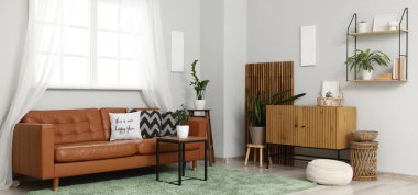 Deri kanepesi, masası, çiçekleri ve tuvaleti olan bir oturma odası.