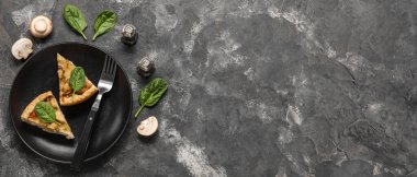 Ispanak yapraklı mantarlı turta ve siyah grunge masasında şampiyonlar.