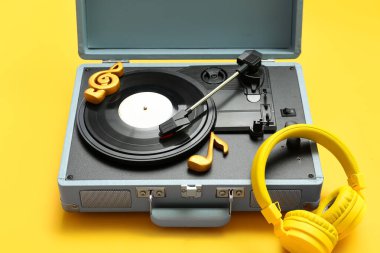 Sarı arka planda plak çalar, nota işaretleri ve kulaklık