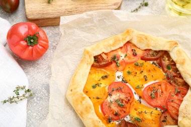 Gri arka planda lezzetli domates galetesi olan kağıt fırını.