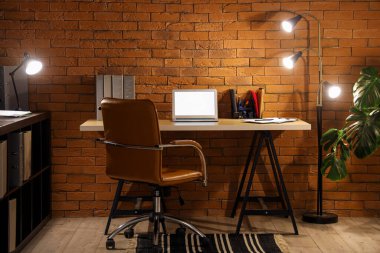 Karanlık ofis, iş yeri, boş laptop ve geceleri parlayan lambalar.