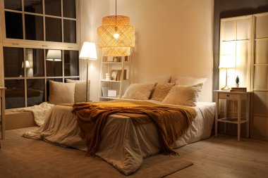 Yatak odasının içi. Yatağında ekose kumaşlar ve geceleri parlayan lambalar var.