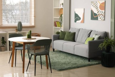 Kanepesi, masası ve raf ünitesi olan şık bir oturma odası.