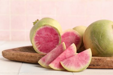 Olgun karpuz turplu ahşap tahta beyaz fayans masasında.