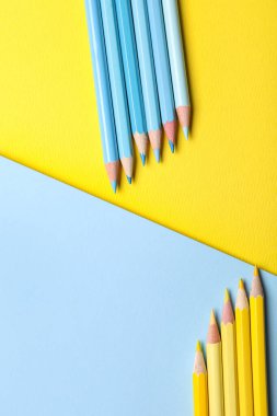 Renkli arka planda mavi ve sarı kalemler