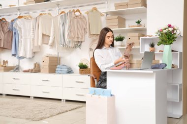 İnternet siparişi ve ayakkabı satan kadın giyim mağazasında çalışıyor.