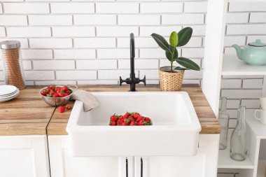 Mutfak lavabosunda lezzetli çilek kasesi.