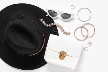 Beyaz arka planda şapka, çanta ve yüzüklerle süslü aksesuarlar. Üst görünüm