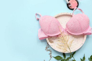 Renkli arka planda şık kadın sütyeni, aksesuar ve çiçek kompozisyonu