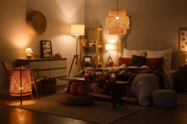 Sonbahar süslemeleri ve akşamları mumları olan şık bir yatak odası.