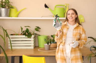 Atölye masasının yanında kesicileri olan kadın bahçıvan.