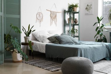 Yatak odasının içi rahat yatak ve çiçeklerle dolu.