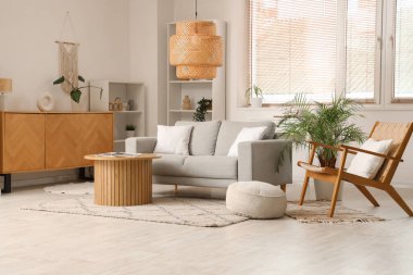 Pencere kenarındaki koltuğu, koltuğu ve şık sehpası olan modern oturma odasının içinde.