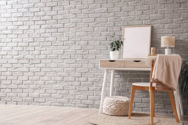 Gri tuğla duvarın yanındaki boş çerçeveli işyeri