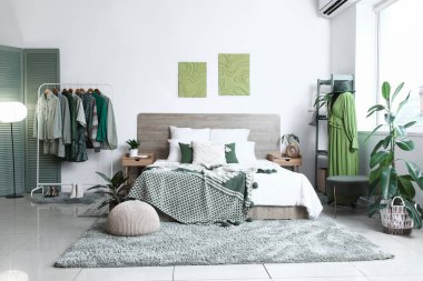 Modern yatak odasının içinde giysi ve mankenlerle dolu raflar.