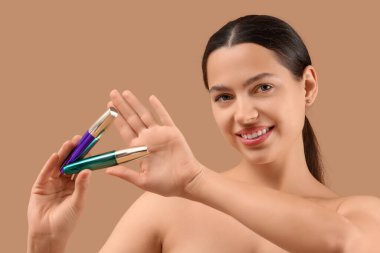 Bej arka planda maskarası olan genç ve güzel bir kadın. Yakın plan.