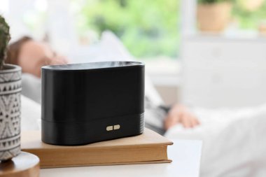 Yatak odasında uyuyan kadına karşı hava nemlendirici, yakın plan.