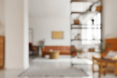 Rahat kahverengi kanepe ve raf ünitesiyle oturma odasının bulanık görüntüsü.