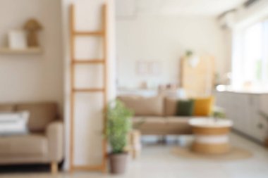 Rahat bej kanepesi ve masası olan bulanık oturma odası manzarası.