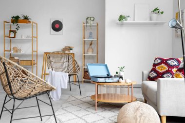 Plak çaları, kanepeleri ve koltukları olan bir oturma odası.