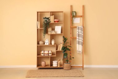 Kitaplı raf ünitesi, oturma odasındaki bej duvarın yanında farklı dekorasyon ve merdiven.