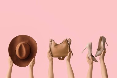 Pembe arka planda şapkalı ve ayakkabılı kadın el çantası.