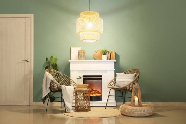 Koltuklu şömine, parlak lamba ve oturma odasındaki turkuaz duvarın yanındaki dekor.