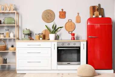 Kırmızı buzdolabı ve beyaz tezgahlı mutfağın içi.