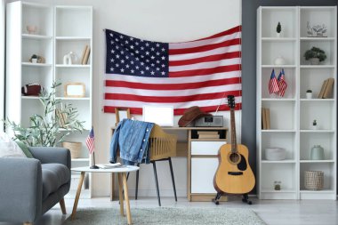ABD bayrağı, gri kanepe ve rahat çalışma alanı olan oturma odasının içinde.