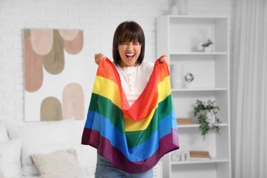 Yatak odasında LGBT bayrağı olan duygusal genç bir kadın.