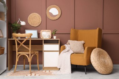 Modern dizüstü bilgisayarı, takvimi, rahat koltuğu ve dekoru olan şık bir iş yeri