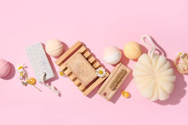 Pembe arka planda spa aksesuarları ve banyo bombaları olan kompozisyon