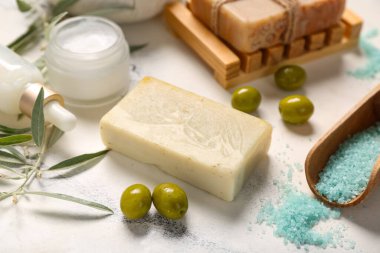 Doğal kozmetik ürünleri ve hafif arkaplanda yeşil zeytinli kompozisyon