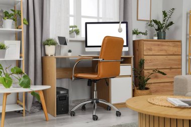 Çalışma odası ve yeşil bitkilerle dolu bir oturma odası.