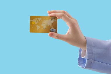 Mavi arka planda kredi kartı olan bir kadın.