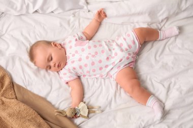 Evde yatağında tavşan oyuncağıyla uyuyan tatlı bir bebek.