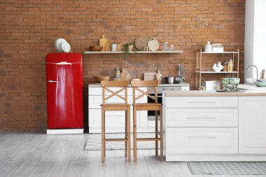 Mutfağın içi retro buzdolabı ve tezgahlarla dolu.